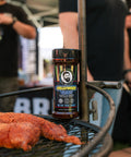 Bottle of Hollywood Blend on a grill with people in the background