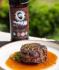 Steak on a plate with a jar of seasoning in the background