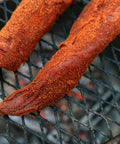 Two tenderloins with a spice rub on a grill grate.