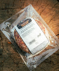 Packaged jalapeno cheddar burgers with a label on a wooden surface