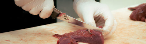 Bearded Butcher branded knife cutting meat