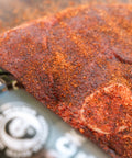 Marinaded beef on a cutting board with a knife