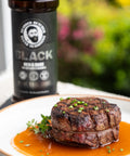 Steak on a plate with a bottle of seasoning in the background