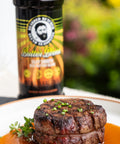 Steak on a plate with a bottle of seasoning in the background