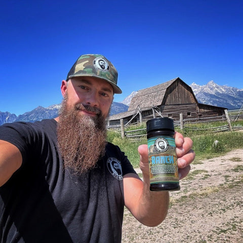 Seth holding Ranch Shaker in front of Barn with fence and mountains