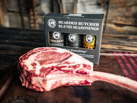 3 Pack of Bearded Butcher Blend Seasoning Shakers in front of Tomahawk Steak
